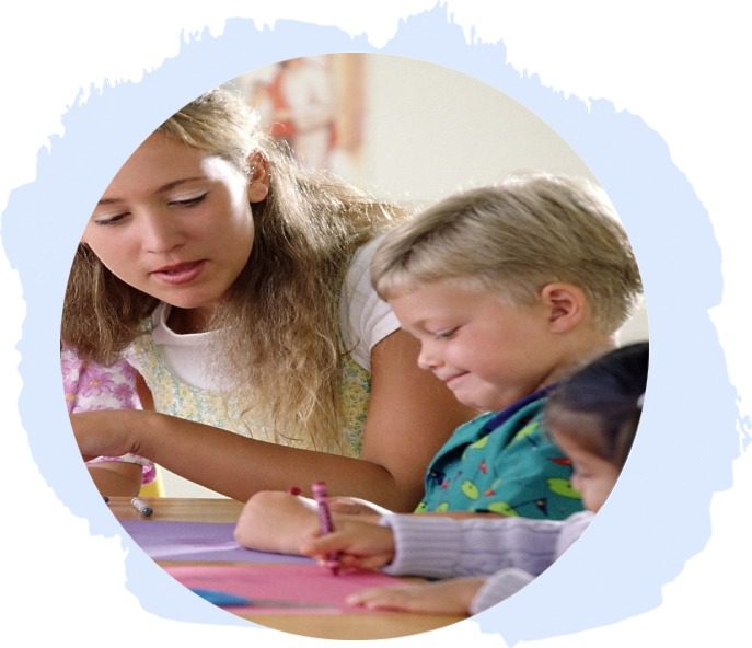 Teacher teaching students at desk in classroom